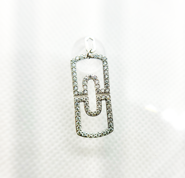 A diamond-encrusted silver pendant in the shape of a paperclip