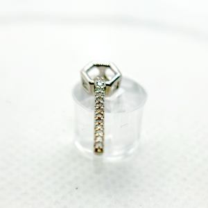A silver line-shaped pendant with small diamond