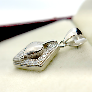 A silver heart-shaped pendant with a diamond-encrusted frame