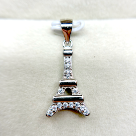 Close-up of a silver Eiffel Tower pendant with embedded diamonds