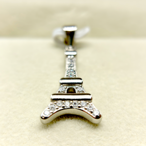Close-up of a silver Eiffel Tower pendant with embedded diamonds