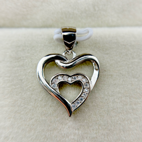 A heart-shaped silver pendant with a smaller heart inside, both adorned with small diamonds