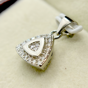 A triangular silver pendant with a smaller triangle inside, both adorned with numerous small diamonds