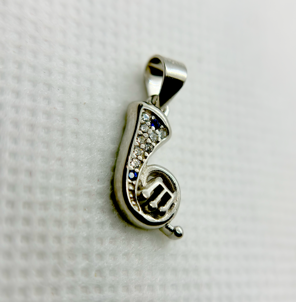 A silver musical note pendant with embedded diamonds