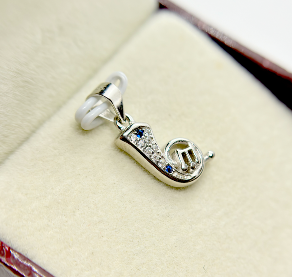 A silver musical note pendant with embedded diamonds