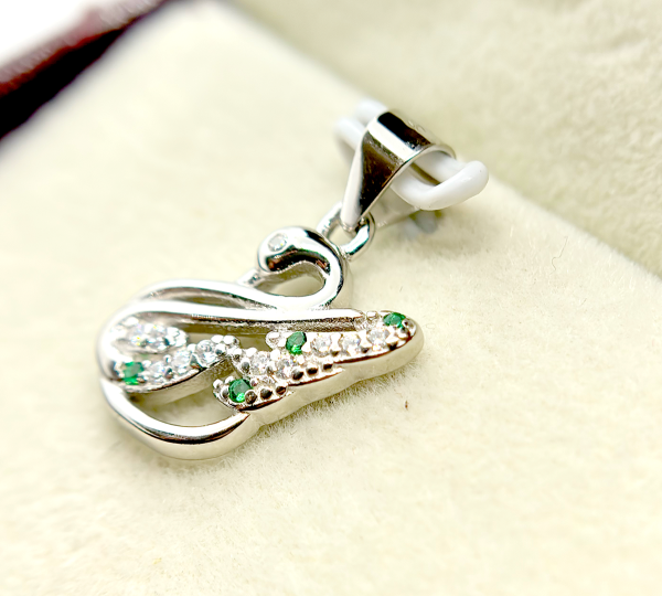 " Silver and green gemstone pendant in the shape of an abstract figure"