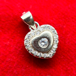 A heart-shaped pendant with a diamond in the center surrounded by smaller diamonds