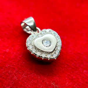 A heart-shaped pendant with a diamond in the center surrounded by smaller diamonds