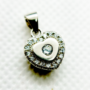 A heart-shaped pendant with a diamond in the center surrounded by smaller diamonds