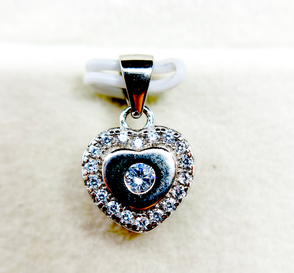 A heart-shaped pendant with a diamond in the center surrounded by smaller diamonds