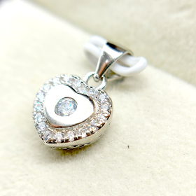 A heart-shaped pendant with a diamond in the center surrounded by smaller diamonds