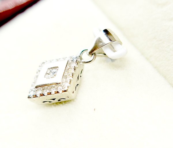 A square-shaped pendant with a concentric diamond design, surrounded by smaller diamonds