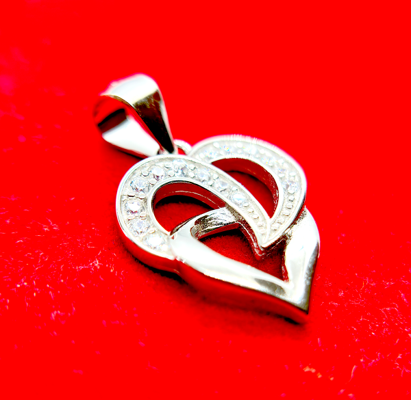 A silver heart-shaped pendant with an intertwined design and small diamond