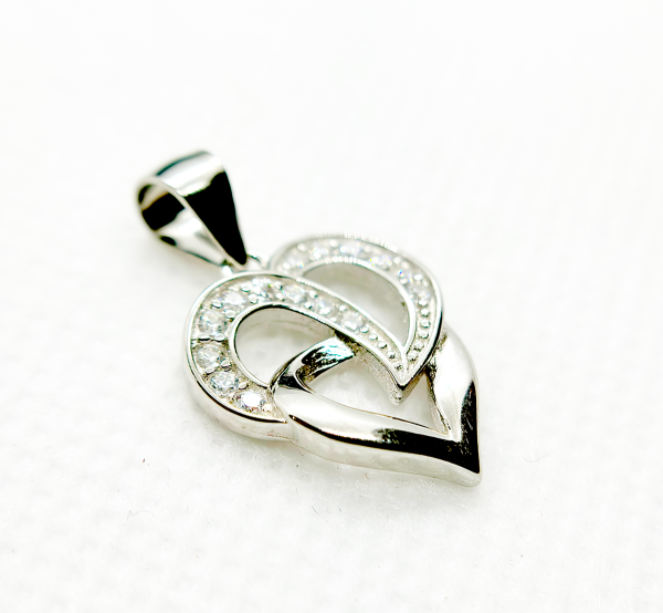 A silver heart-shaped pendant with an intertwined design and small diamond