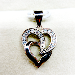 A silver heart-shaped pendant with an intertwined design and small diamond