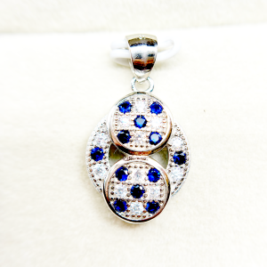 Silver pendant with three interconnected circular elements, each set with blue gemstones and surrounded by smaller diamonds
