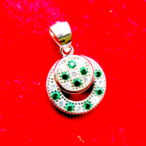 A circular pendant with green and clear gemstones set in a silver