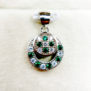 A circular pendant with green and clear gemstones set in a silver