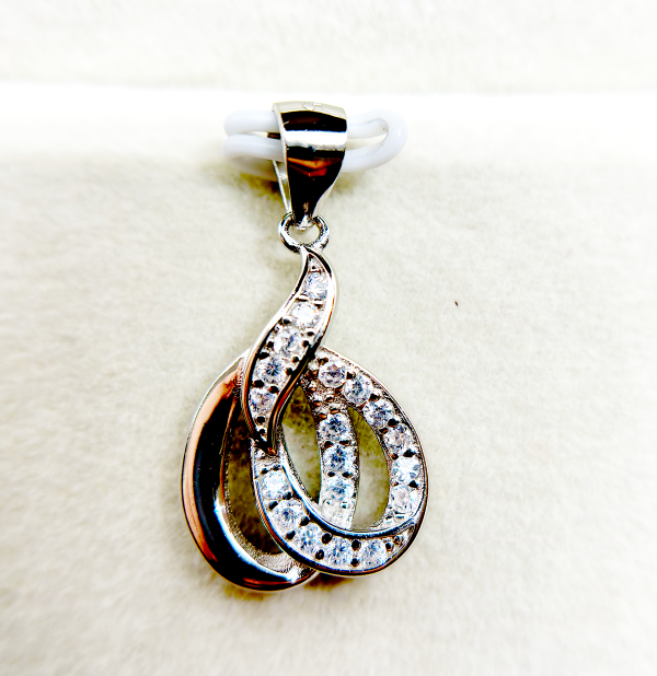 A silver pendant with a swirling design and embedded with small diamonds