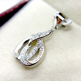 A silver pendant with a swirling design and embedded with small diamonds